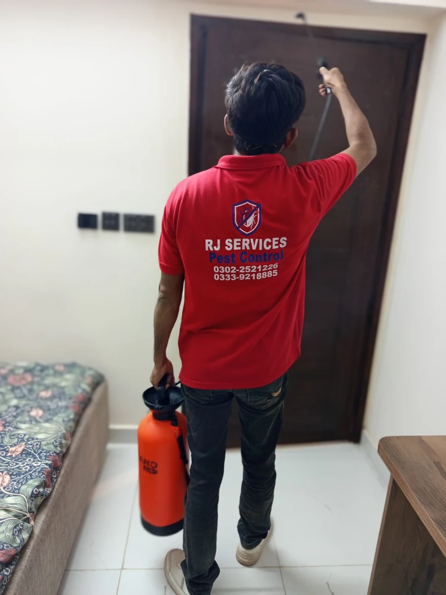 Rana Jees Fumigation Services technician applying an indoor treatment around a doorway